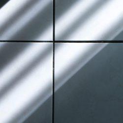 A minimalist image capturing sunlight casting shadows on tiled flooring.