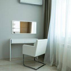 Modern minimalist interior featuring a chair, table, and air conditioning unit.